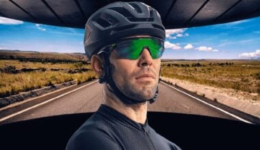 a bike rider in sunglasses stands