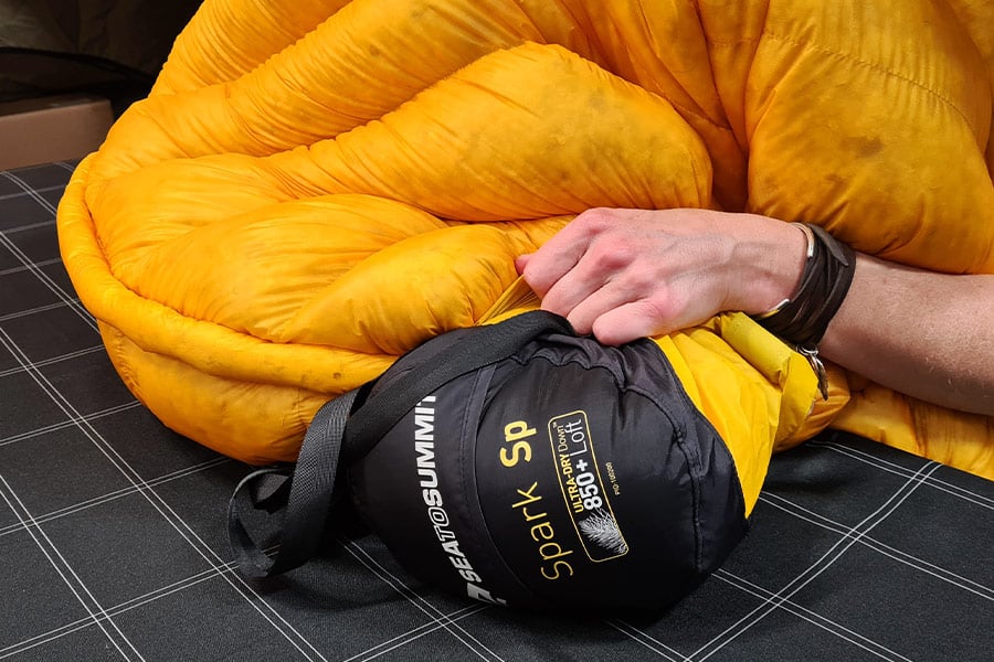 a man packs a sleeping bag